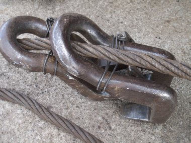 Ağır metal prangalar, kalın çelik kabloyu birbirine sıkıca bağlıyor.