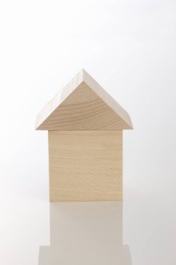Beyaz arka planda izole edilmiş ahşap oyuncak ev modeli. Emlak kavramı.
