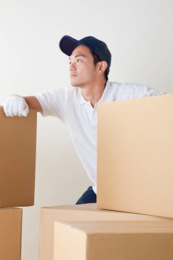 Depoda kutuları olan genç erkek kurye.