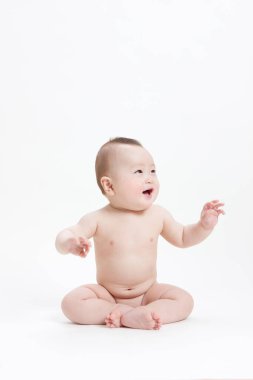 Beyaz arka plan üzerinde oturan şirin bebek.