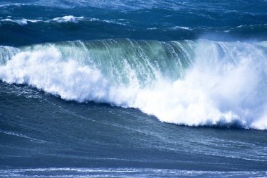 Denizdeki dalgaların gündüz görüntüsü. Denizin üzerindeki mavi gökyüzü