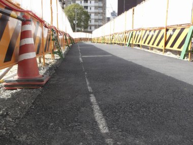 İnşaat alanı yeni asfaltlanmış yolları bariyerlerle gösteriyor