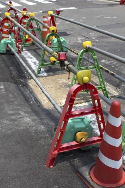 Yol inşaat malzemelerini çevreleyen renkli trafik konileri