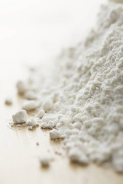 Ahşap arka planı olan beyaz un yığını.