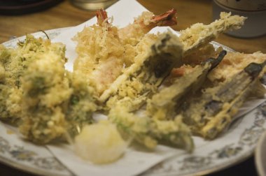 Soslu kızarmış deniz ürünleri ve beyaz tabakta limon. 