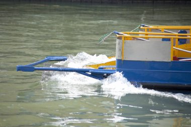 Durgun suda hareket eden renkli tekne küçük dalgalar yaratır