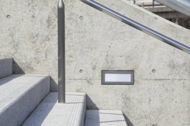 Metal parmaklıklı ve ışıklı modern beton merdivenler.