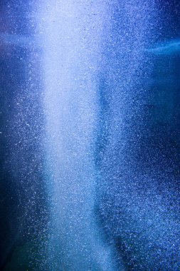 Mavi denizin derinliklerinden yükselen su kabarcıkları.