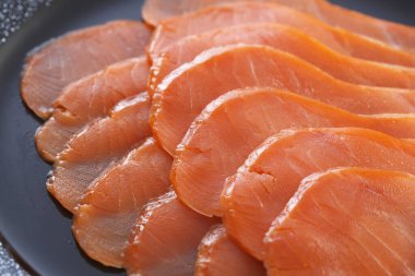 Arka planda tabakta taze somon filetosu, yakın plan.