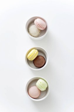 colorful macaroons in bowls, top view 