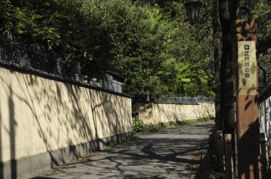 Gün boyunca uzun taş duvarın yanında dar gölgeli dar sokaklar