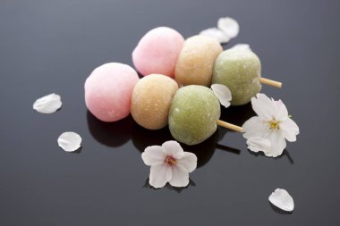 Lezzetli yuvarlak tatlılar çiçekler ve taç yapraklarıyla servis edilir. Japon Mochi. 