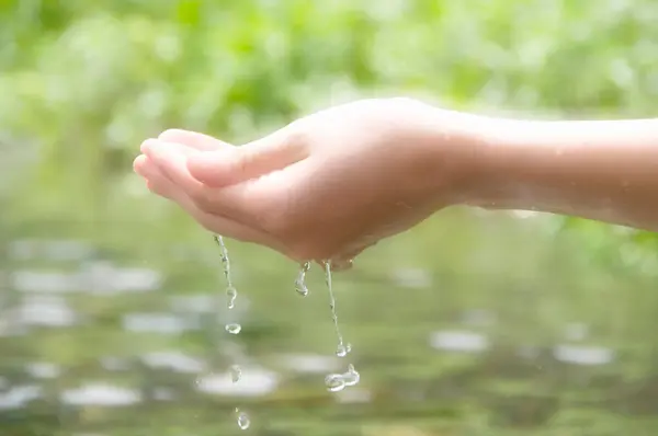 屋外で手を洗っている女性 ヤシの中の自然な飲料水 水スプラッシュ付きハンド — ストック写真