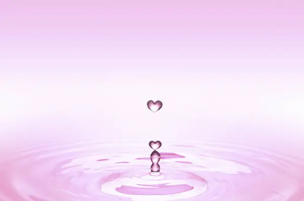Rosafarbene Herzförmige Wassertropfen Fallen Auf Die Wasseroberfläche — Stockfoto