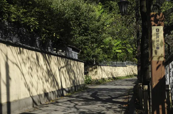 Gün boyunca uzun taş duvarın yanında dar gölgeli dar sokaklar