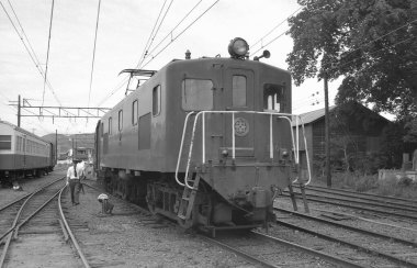 Tren raylarında giden bir trenin siyah beyaz fotoğrafı..