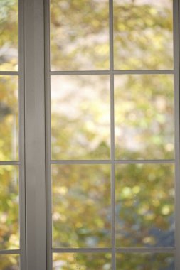 Sonbahar yapraklarının arka planına sahip güzel beyaz bir pencere çerçevesinin iç görünümü