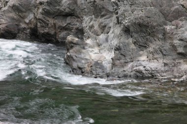 Dalgalar kayalara çarpıyor.