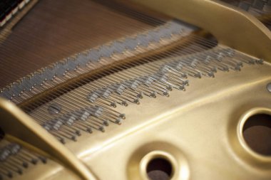 Büyük piyano çerçevesi içinde karmaşık metal telleri gösteren yakın plan