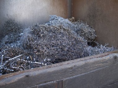Endüstriyel konteynırın içinde parlak metal talaşları var.