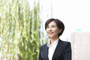 Açık havada gülümseyen genç bir kadın