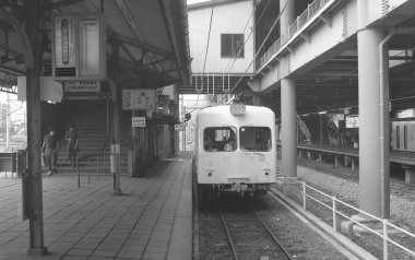 Bir tren istasyonunun siyah beyaz fotoğrafı.