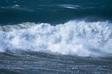 Denizdeki dalgaların gündüz görüntüsü. Denizin üzerindeki mavi gökyüzü