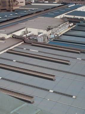 Hava görüntüsü endüstriyel binaların çatılarını ve yapılarını gösteriyor