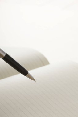 beyaz arkaplanda beyaz defter sayfaları ve kalem 