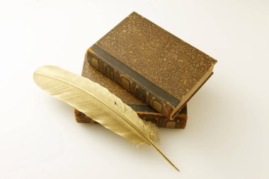 Beyaz arkaplanda izole edilmiş eski kitaplar ve tüy