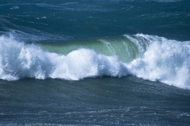 Denizdeki dalgaların gündüz görüntüsü. Denizin üzerindeki mavi gökyüzü