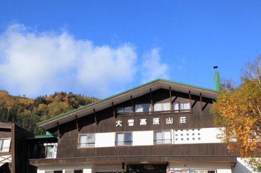 Eski bir kasabada ahşap bir ev ve açık mavi bir gökyüzü. 