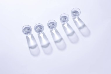 Beyaz zemin üzerinde su olan bardakların üst görünümü