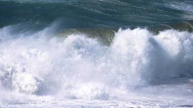 Denizdeki dalgaların gündüz görüntüsü. Denizin üzerindeki mavi gökyüzü