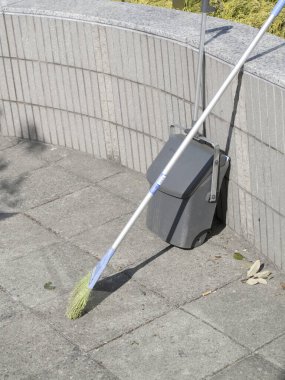 Açık havada gri duvara yaslanmış temizlik aracı