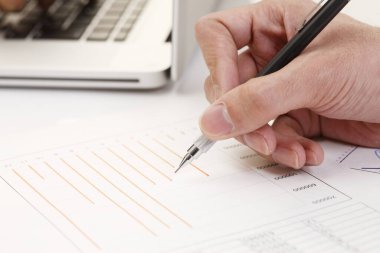 Mali verileri tablolar ve rakamlarla analiz eden, finans ve yatırıma odaklı profesyonellerin yakın plan görüntüleri.