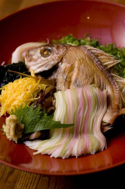 Balık kafasının süslendiği renkli Japon saşimi yemeği.