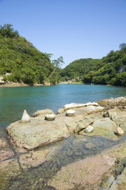 Taşları ve dağ nehri olan kayalık sahil manzarası