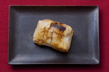 Siyah tabakta soslu ızgara balık