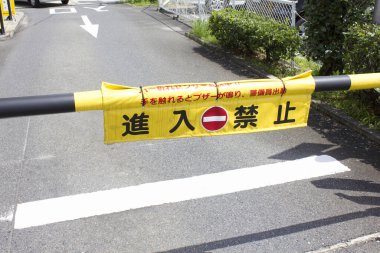 Sarı bariyer Japon uyarı işareti ile dar yolu kapatıyor.