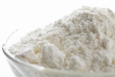 Beyaz zemin üzerinde bir kapta buğday unu