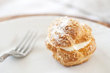 Lezzetli kremalı pasta ve çatal beyaz tabakta. 