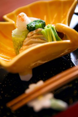 Japon aperatifleri sarı tabağın içinde dinleniyor.