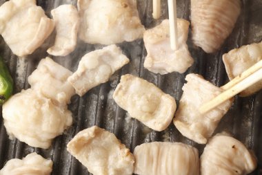 Et parçalarını ızgarada çeviriyor yemek çubukları, lezzetli barbekü çubukları kullanıyor.