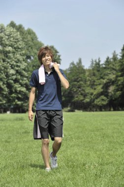 Genç adam parkta koştuktan sonra