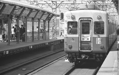Japon demiryollarından geçen siyah beyaz tren görüntüsü.