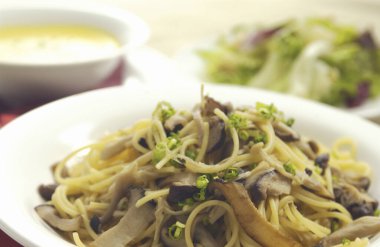 Beyaz tabakta mantarlı lezzetli erişteleri yakın.