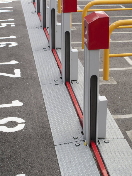 Metal barriers lining parking lot with numbered spaces