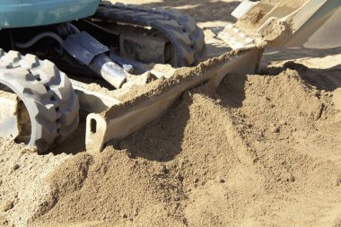Buldozer gündüz inşaat sırasında kuru kumu itiyor.