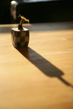 Çiçek dökme gölgesi olan küçük vazo.